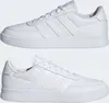 Two views of a pair of white Adidas sneakers against a white background. Voir les images du produit
