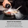 A person is pouring liquid into a frying pan on an induction hob, with steam rising. Náhľad obrázku produktu
