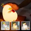 A hand touching a glowing duck-shaped night light, with smaller inset images showing the product in different lighting conditions. Produktbild-Vorschau