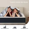 A couple lying on a mattress under a blanket. Voir les images du produit