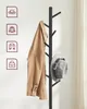 A close-up of a black coat rack with a tan jacket and a gray hat hanging on it, against a white background. Náhled obrázku produktu