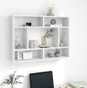 A white wall-mounted shelf unit filled with decorative items. Voir les images du produit
