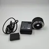 A Canon lens, battery, and charger are laid out on a white background. Náhľad obrázku produktu