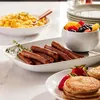 A breakfast spread with sausages, scrambled eggs, fruit salad, and pancakes. Anteprima dell’immagine prodotto