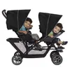 Two young boys sitting in a double stroller. Voir les images du produit