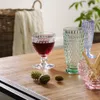 A collection of decorative glassware and small spiky decorative objects are arranged on a wooden table. Náhled obrázku produktu