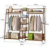 A bamboo garment rack with various items displayed on it, including clothes, bags, boxes, and shoes. Produktbild-Vorschau