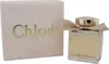 Chloé Absolu de Parfum in geriffeltem Glasflakon mit goldener Kappe und beigefarbener Schleife, daneben elegante rosa Verpackung mit goldener Schrift. Podgląd zdjęcia produktu