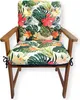 A chair cushion with a tropical floral pattern is placed on a wooden chair. Produktbild-Vorschau