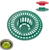 A collection of drain strainers in different colors, with one green strainer prominently displayed in the center, and a smaller inset image showing a green strainer in a sink. Podgląd zdjęcia produktu