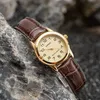 A gold-colored Casio watch with a brown leather strap rests on rocks and dark sand. Produktbild-Vorschau