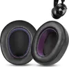 Two black ear pads with purple lining are shown against a white background. A portion of a black headphone is visible in the upper right corner. Náhled obrázku produktu