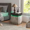 A modern bedroom scene with a nightstand next to a bed, illuminated by a lamp and LED lights. Produktbild-Vorschau