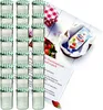 A collection of glass jars with green checkered lids, a packet of jelly powder, and some strawberries, arranged on a white surface with a recipe card. Produktbild-Vorschau