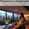 A woman stands in a modern kitchen with a city skyline visible through the window, next to a blender. Produktbild-Vorschau