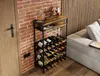 A wine rack filled with wine bottles and glasses, placed next to a sofa in a living room with a brick wall. Podgląd zdjęcia produktu