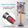 A wall-mounted docking station for a Dyson vacuum cleaner and its attachments, with a close-up inset showing a quick release button. Produktbild-Vorschau