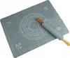 A grey silicone baking mat with measurement markings and illustrations, and a rolling pin with wooden handles. Podgląd zdjęcia produktu