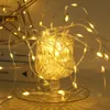 A close-up of a string of warm white LED lights coiled inside a decorative glass vase. Produktbild-Vorschau