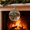 A Christmas ornament with a hummingbird inside hangs in front of a fireplace. Produktbild-Vorschau
