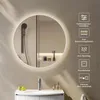 A round LED mirror with integrated lighting is shown above a sink in a modern bathroom setting. The mirror reflects a showerhead and some toiletries. Icons and text describing the mirror's features are displayed to the right of the mirror. Anteprima dell’immagine prodotto