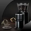 A coffee grinder with coffee beans and a cup of coffee on a wooden table. Produktbild-Vorschau