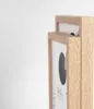A close-up side view of two wooden picture frames stacked on top of each other against a white background. Produktbild-Vorschau