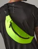 A person wearing a black t-shirt with a neon green fanny pack across their chest. Anteprima dell’immagine prodotto