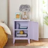 A purple nightstand with an open door, displaying books, a vase, and a decorative box. A lamp and a picture frame are on top of the nightstand. Anteprima dell’immagine prodotto