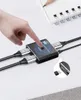 A hand is pressing a button on a black and silver HDMI switch connected to cables. Produktbild-Vorschau
