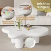 A white cloud-shaped coffee table is shown in a living room setting with a sofa in the background. Insets highlight the table's features. Produktbild-Vorschau