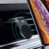 A magnetic phone holder attached to a car's air vent, with a smartphone being held by it. Voir les images du produit