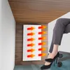 A person's legs and feet are shown under a desk, with a white panel emitting heat arrows towards them. Voir les images du produit