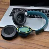 Disassembled headphones are placed on a laptop and a wooden surface. Podgląd zdjęcia produktu
