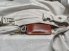 A close-up view of a brown leather wallet and keys inside a light-colored bag. Anteprima dell’immagine prodotto