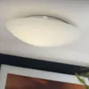 A white ceiling light fixture is mounted on a white ceiling. Produktbild-Vorschau