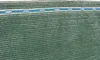 A close-up view of a green mesh fabric with a blue and white striped band near the top edge. Náhled obrázku produktu