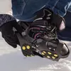 A person is putting on ice cleats over their boots in the snow. Anteprima dell’immagine prodotto