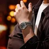 A man wearing a watch and jacket, with a blurred background of lights. Anteprima dell’immagine prodotto