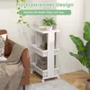 A white three-tier rolling cart with a tabletop is shown next to a brown sofa and a large green plant. The cart contains books, a plant, and other items. Produktbild-Vorschau