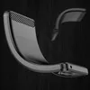 A black phone case with carbon fiber accents is shown dynamically bending against a dark, textured background. Produktbild-Vorschau