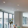 A modern interior with large windows and a decorative table with flowers and drinks. Produktbild-Vorschau