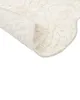 A close-up view of a beige bath mat, showing its textured surface and a folded corner. Náhled obrázku produktu