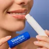 A close-up shot of a person applying Vaseline lip balm to their lips. Produktbild-Vorschau