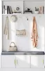A white entryway storage unit with a bench, coat hooks, and shelves, styled with accessories like a hat, scarf, handbag, and coat. Anteprima dell’immagine prodotto