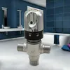 A bathroom setting with a bathtub and sinks, featuring a thermostatic mixing valve in the foreground. Produktbild-Vorschau