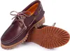 A pair of burgundy leather boat shoes with a thick lug sole, shown from a slightly elevated side angle against a white background. One shoe is upright, and the other is lying on its side, revealing the sole. Anteprima dell’immagine prodotto