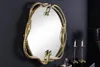 A decorative mirror with a snake-shaped frame is mounted on a dark gray wall. Produktbild-Vorschau