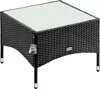 A black polyrattan garden side table with a glass top, shown from a diagonal angle on a white background. Anteprima dell’immagine prodotto