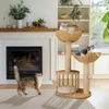 A cat tree with two cats on it, and another cat on the floor in front of a fireplace. Náhľad obrázku produktu